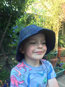 Child wearing oilskin tartan hat made from digital download pattern
