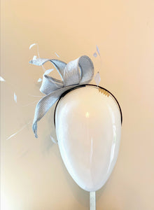 Silver straw fascinator with feathers on a headband. Front view.