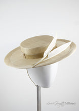 Natural coloured straw boater hat with two cream feathers. Handmade London Millinery. Side view.