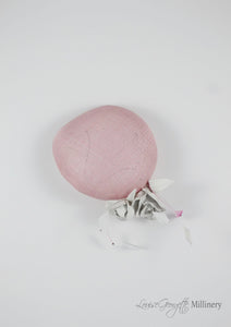 Pink sinamay Beret with white handmade leather flower. Top view of model. Handmade Millinery made in London.