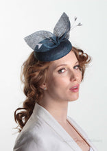 Royal Blue straw bow hat with feathers. Royal enclosure approved. Millinery handmade in London. Louise Georgette Millinery. Model side view.