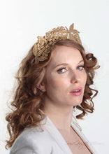 Lacey tiara style gold  crown on headband. Model side view. Millinery handmade in London.