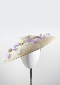 Wide brimmed disc hat with lilac and white flowers. Front view. Handmade in London.