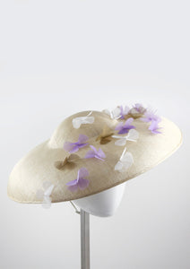 Wide brimmed disc hat with lilac and white flowers. Side view. Handmade in London.