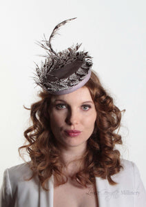 Victoria Pillbox hat with leather base and Lady Amherst feather. Model front view.  Millinery handmade in London.