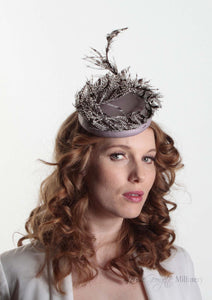 Victoria Pillbox hat with leather base and Lady Amherst feather. Model side view.  Millinery handmade in London.